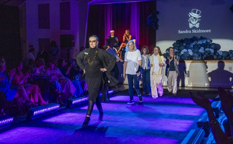 Behind-the-scenes supporters get a chance to walk the runway.